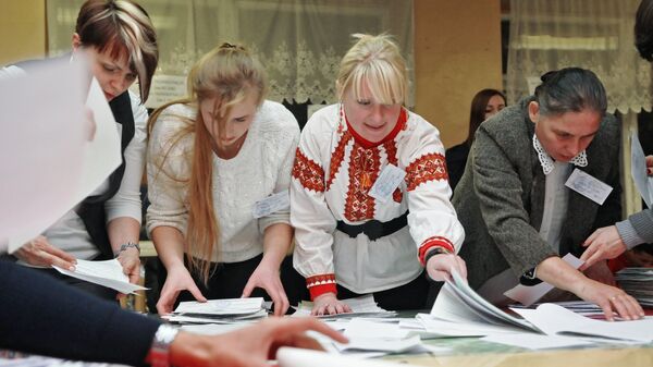 Сотрудники участковой избирательной комиссии на одном из избирательных участков Львова во время подсчета голосов на выборах