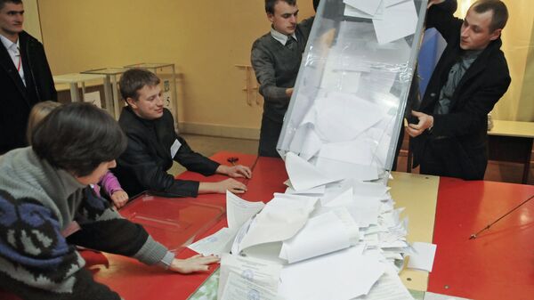 Сотрудники участковой избирательной комиссии на одном из избирательных участков Львова во время подсчета голосов