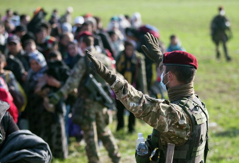 Словенский военный управляет движением беженцев, прибывших из Хорватии