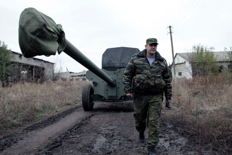 Военнослужащий у военной техники, отведенной от линии соприкосновения ДНР, на специально подготовленной площадке в Донецкой области