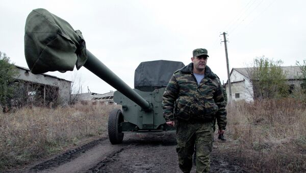 Военнослужащий у военной техники, отведенной от линии соприкосновения ДНР, на специально подготовленной площадке в Донецкой области