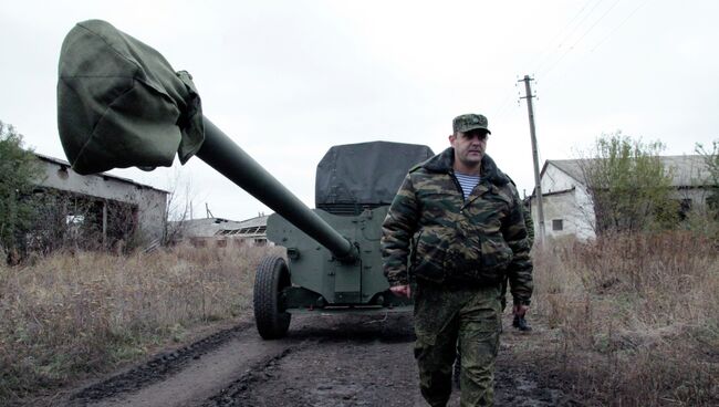 Военнослужащий у военной техники, отведенной от линии соприкосновения ДНР, на специально подготовленной площадке в Донецкой области