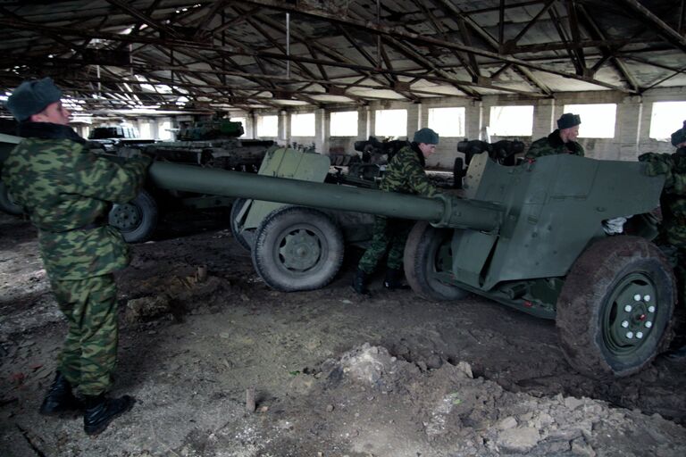 Военнослужащий у военной техники, отведенной от линии соприкосновения ДНР, на специально подготовленной площадке в Донецкой области