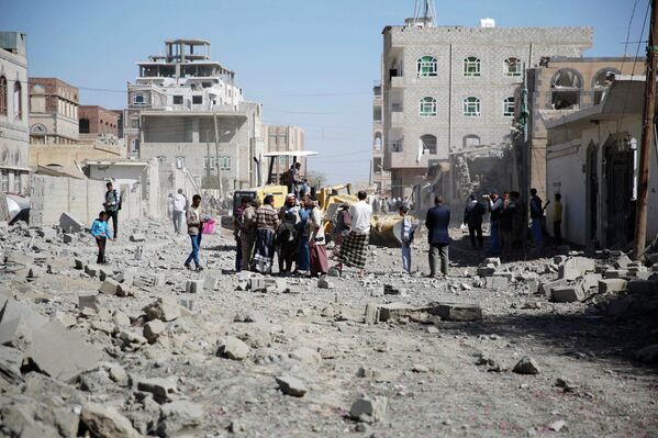 Люди на улице в столице Йемена Сане после нанесенного силами арабской коалиции авиаудара