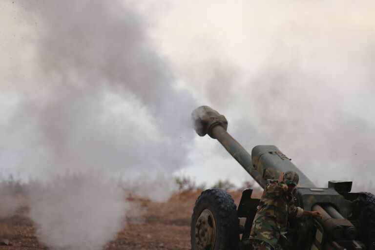 Военнослужащие сирийской армии ведут артиллерийский обстрел позиций боевиков на севере сирийской провинции Хама