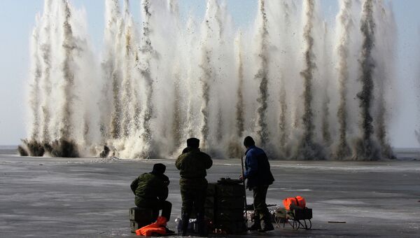 Сотрудники МЧС осуществляют подрыв льда в Куршском заливе в устье реки Матросовка. Фотография из серии Игоря Зарембо Люди и время