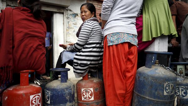 Женщина во время ожидания в очереди, чтобы купить бытовой газ в Катманду, Непал