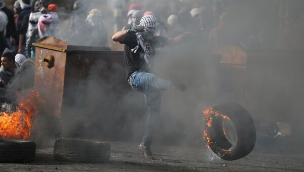 Палестинский протестующий во время столкновений с израильскими военными недалеко от города Рамалла