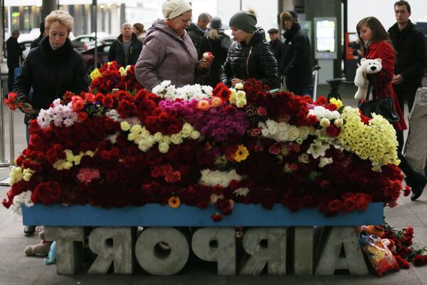 Местные жители возлагают цветы у входа в Аэропорт Пулково в память о жертвах авиакатастрофы российского авиалайнера в Египте