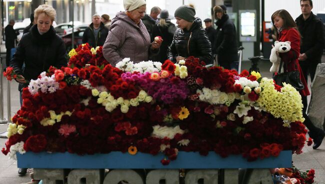 Местные жители возлагают цветы у входа в Аэропорт Пулково в память о жертвах авиакатастрофы