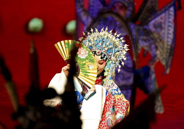 Актриса оперы Пекина выступает во время Недели моды в Китае, Пекин. Октябрь 2015