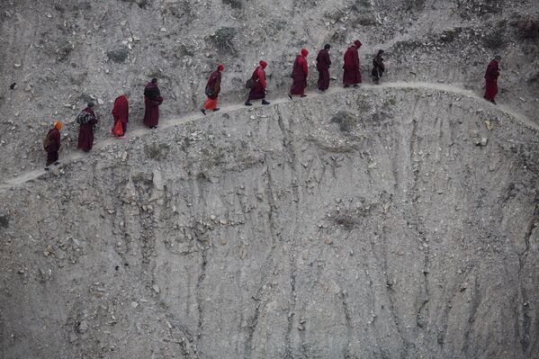 Буддистские монахи и монахини возвращаются после дневных песнопений, Тибетский автономный район, КНР