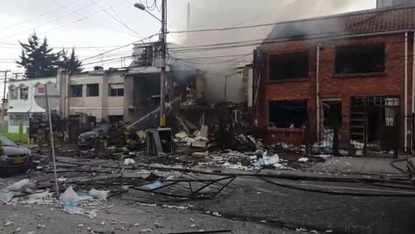 Пожарные заливали водой дымящиеся руины здания на месте взрыва в Боготе