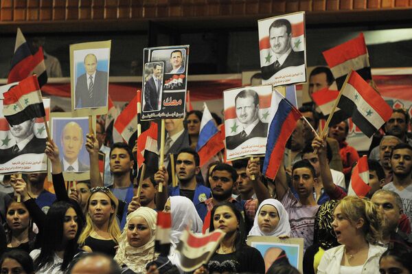 Жители Сирии с флагами Сирии, России и российских Воздушно-космических сил