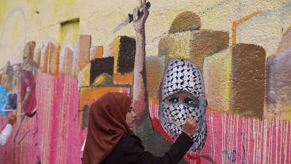 Палестинская женщина рисует картину в поддержку атак против израильтян на юге сектора Газа