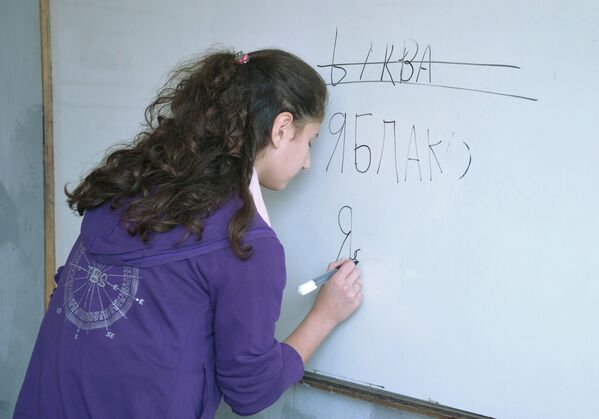 Ученица 7-го класса женской школы имени Сухеля Абу Ашшамлята в Латакии пишет слова на доске на уроке по русскому языку
