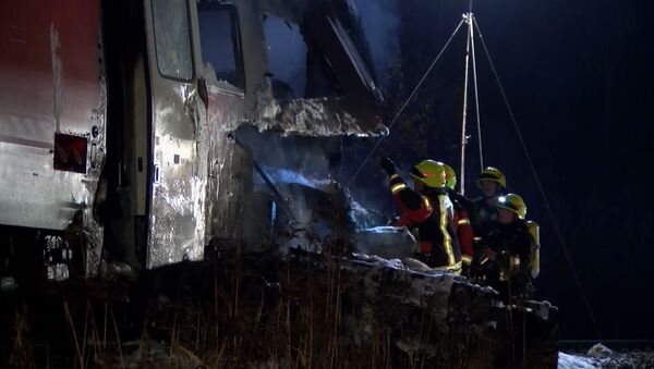 Спасатели с фонарями осматривали столкнувшийся с поездом тягач в Германии
