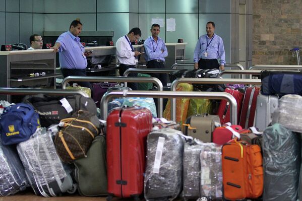 Сотрудники аэропорта курорта Шарм-эш-Шейх с багажом в терминале вылета, Египет. Ноябрь 2015