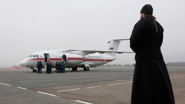 Священнослужитель наблюдает в аэропорту Пулково в Санкт-Петербурге за самолетом МЧС России, доставившим тела жертв крушения Airbus A321 авиакомпании Когалымавиа