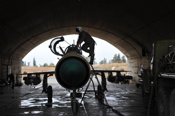 Сирийский летчик осматривает самолет МИГ-21 сирийских ВВС перед вылетом на авиабазе Хама