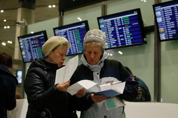 Пассажиры проверяют свои документы после возврата билетов до Египта. Аэропорт Пулково, Санкт-Петербург