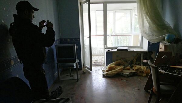 Сотрудники Совместного центра по контролю и координации режима прекращения огня в Донбассе и представители Специальной мониторинговой миссии ОБСЕ на месте обстрела. Архивное фото