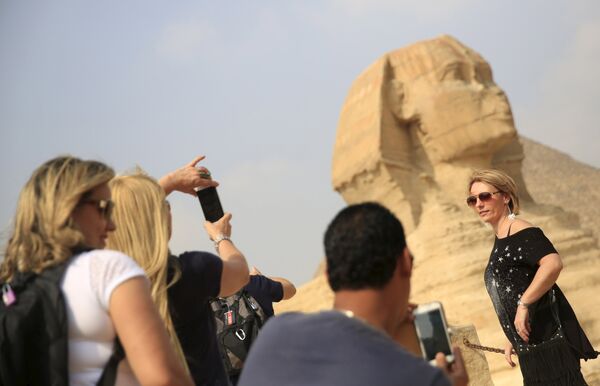 Туристы фотографируются перед Сфинксом