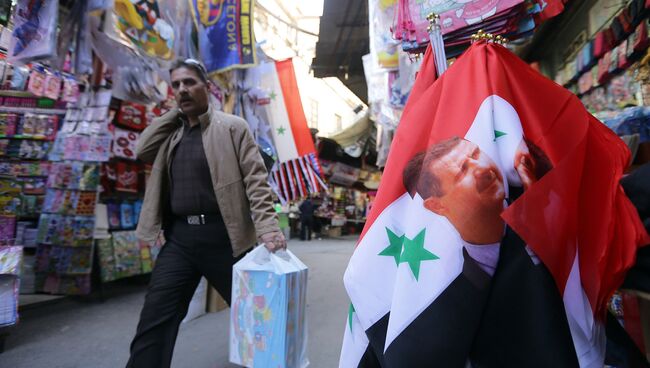 Флаг Сирии с изображением президента Сирии Башара Асада на рынке в Дамаске. Сирия, ноябрь 2015. Архивное фото