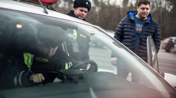 Сотрудник ГИБДД проверяет документы у водителя в рамках рейда скрытых патрулей ДПС в Москве. Архивное фото