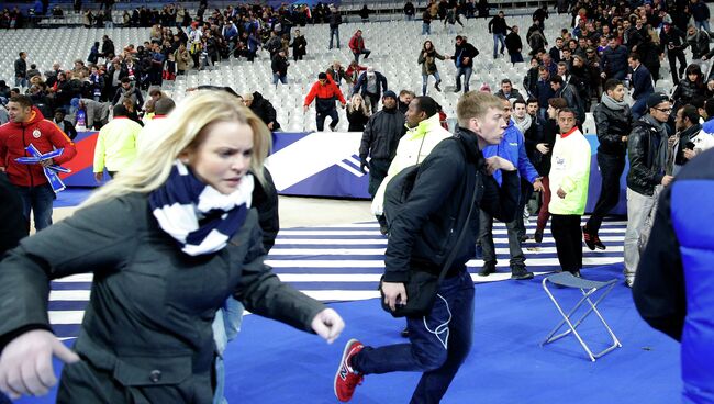 Эвакуация людей со стадиона Stade de France, где прогремели взрывы. Архивное фото