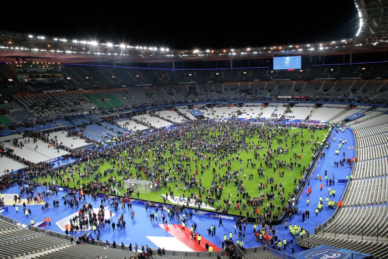 Эвакуация людей со стадиона Stade de France, где прогремели взрывы