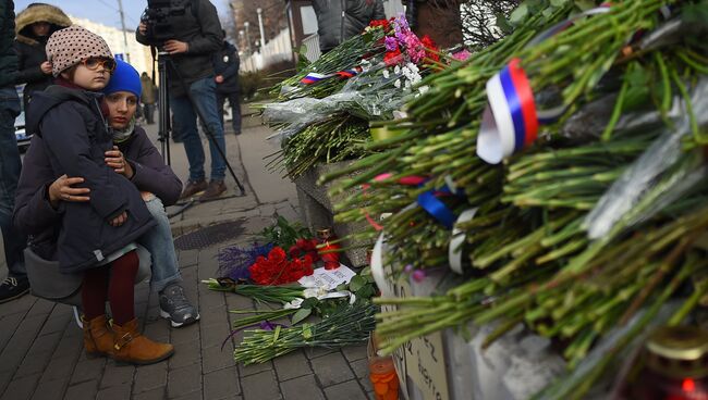 Люди оставляют цветы в память о погибших в теракте у посольства Франции в Москве