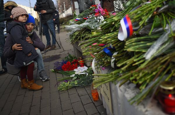Люди оставляют цветы в память о погибших в теракте у посольства Франции в Москве