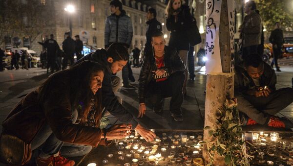 Горожане возлагают цветы свечи на Площади Республики в Париже. Архивное фото
