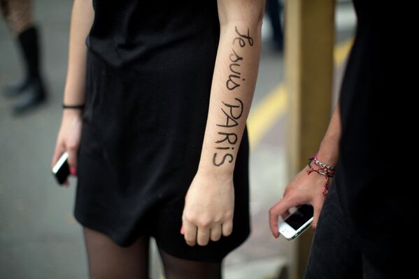 Надпись на руке в память о жертвах террористического акта в Париже