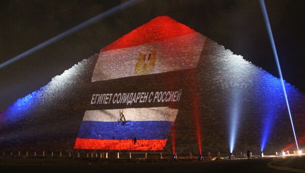 Древнеегипетская пирамида Хеопса на плато Гиза в Каире, подсвеченная цветами российского и египетского флагов во время акции памяти жертв