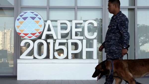Полицейский идет мимо эмблемы саммита АТЭС в Маниле