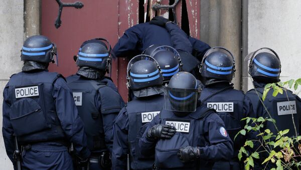 Французские полицейские взламывают дверь в церкви в Сен-Дени
