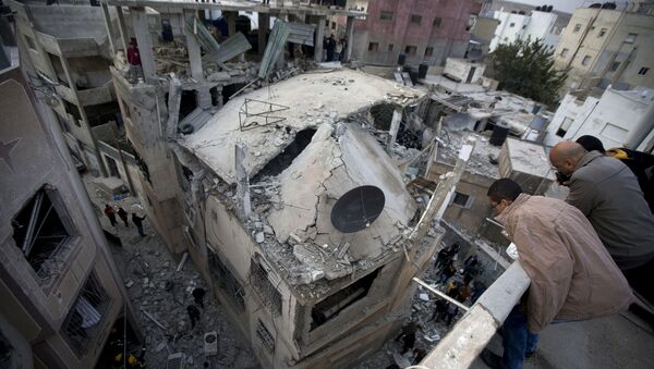 Палестинцы смотрят на дом, разрушенный израильской армией, на окраине города Рамалла. Архив