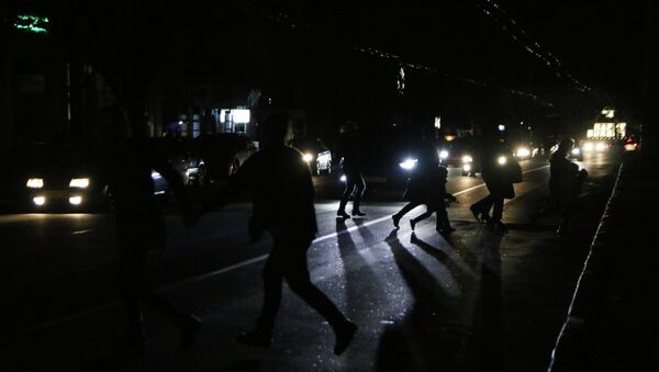 Жители Симферополя переходят автодорогу в свете фар автомобилей