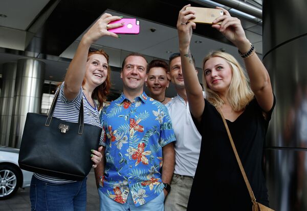 Председатель правительства РФ Дмитрий Медведев фотографируется с российскими и украинскими туристами во время осмотра достопримечательностей столицы Малайзии Куала-Лумпура