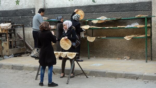 Горожане раскладывают горячий хлеб в Старом городе Дамаска