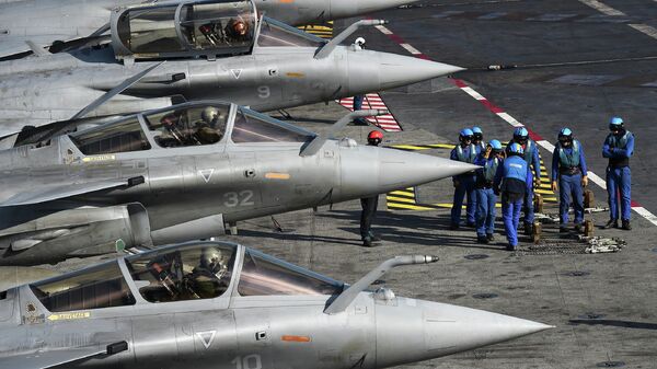Французские военные техники проводят подготовку истребителей Рафаль на палубе авианосца Шарль де Голль