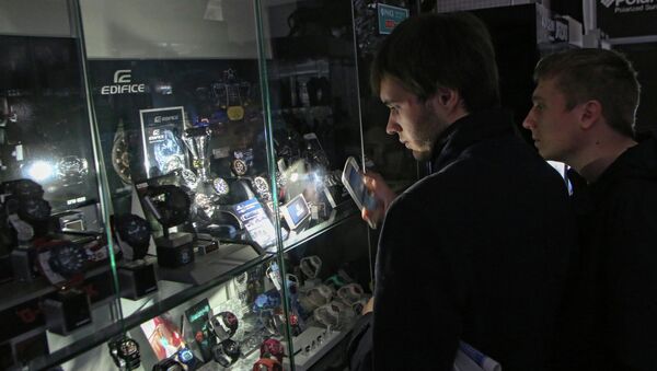 Покупатели в одном из магазинов Симферополя рассматривают товары подсвечивая их мобильным телефоном