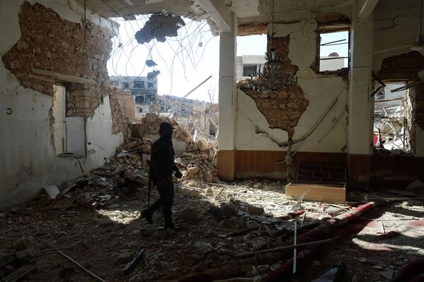 Боец Сирийской арабской армии (САА) в разрушенной мечети в пригороде Дамаска Дахание