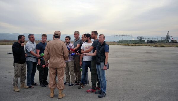 Спасенный летчик Су-24 Военно-космических сил России капитан Константин Мурахтин (в центре) отвечает на вопросы журналистов на авиабазе Хмеймим