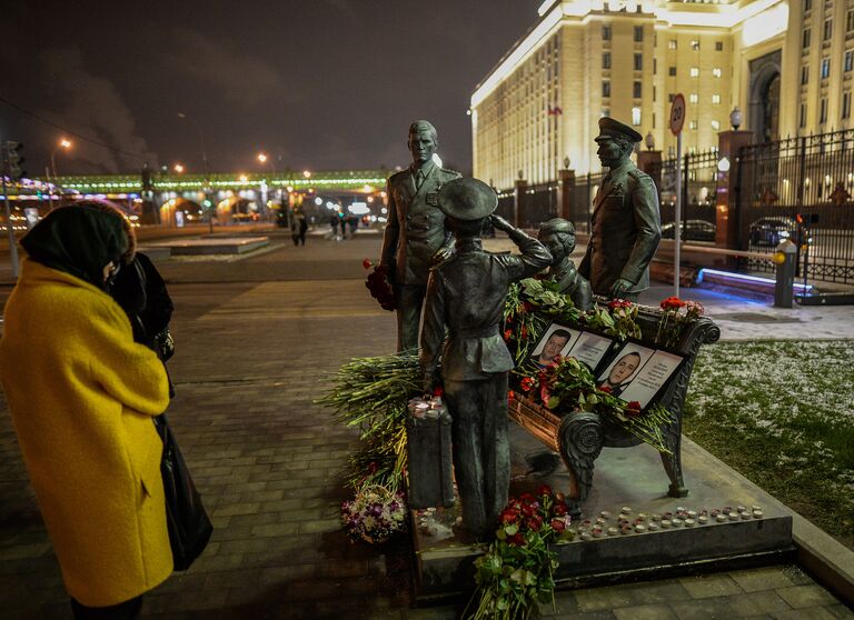 Портреты погибших в Сирии подполковника Олега Пешкова и матроса Александра Позынича и цветы у памятника героям фильма Офицеры