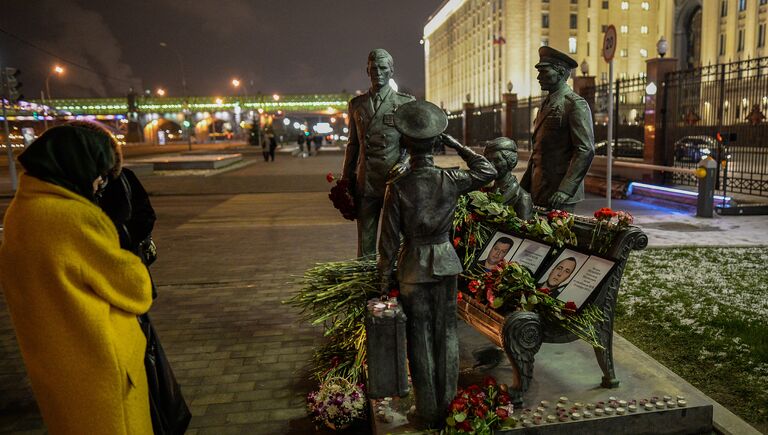 Портреты погибших в Сирии подполковника Олега Пешкова и матроса Александра Позынича и цветы у памятника героям фильма Офицеры