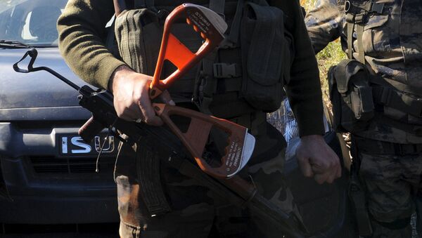 Вооруженный сирийский туркмен держит ручки катапультируемого кресла погибшего летчика Су-24