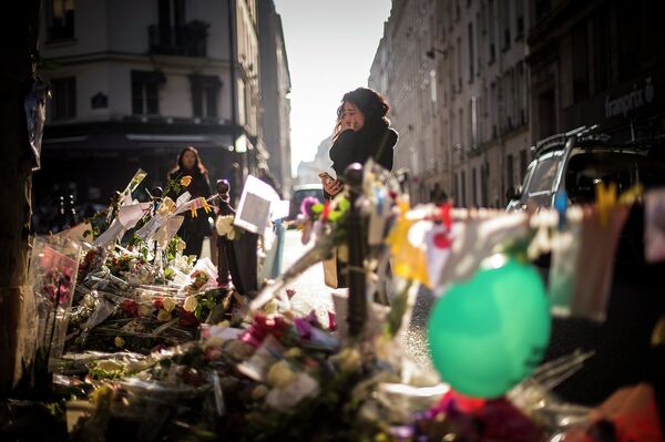 Девушка у импровизированного мемориала жертвам погибших в терактах в Париже